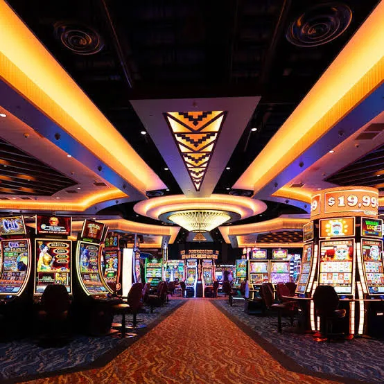 Brightly lit casino floor lined with slot machines