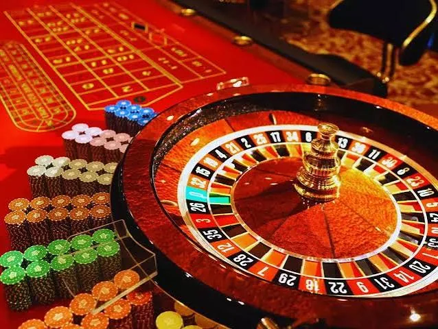 Live roulette wheel with chips on a red casino table